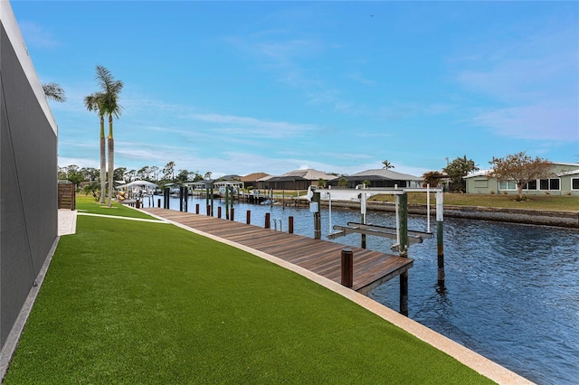 view of dock with a water view and a yard