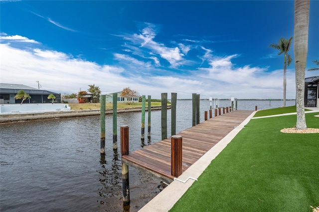 view of dock with a water view and a lawn