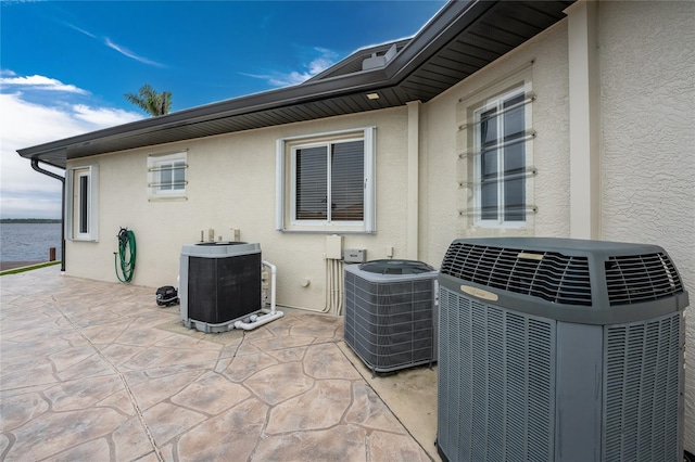 exterior space featuring central air condition unit and a water view