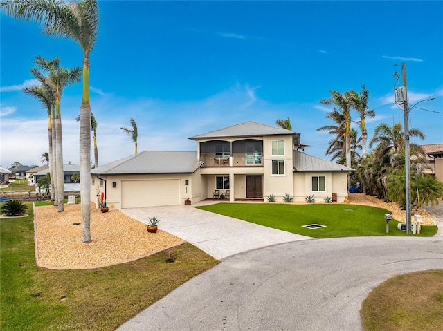 view of front of home featuring a front lawn, a balcony, and a garage