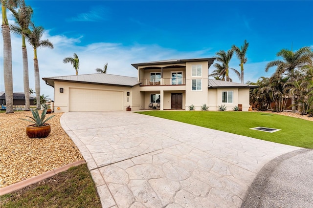 view of front of property featuring a front yard, a balcony, and a garage