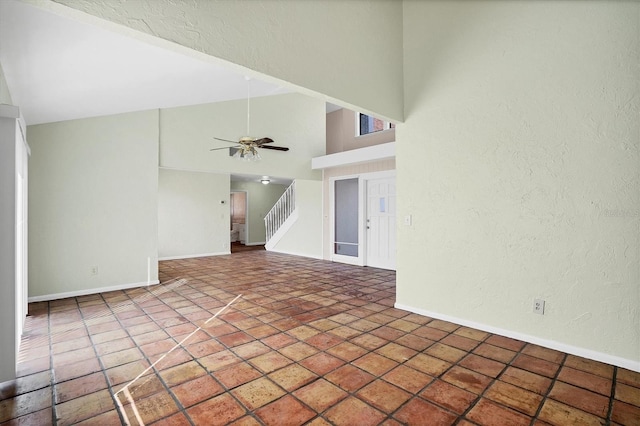 unfurnished living room with high vaulted ceiling and ceiling fan