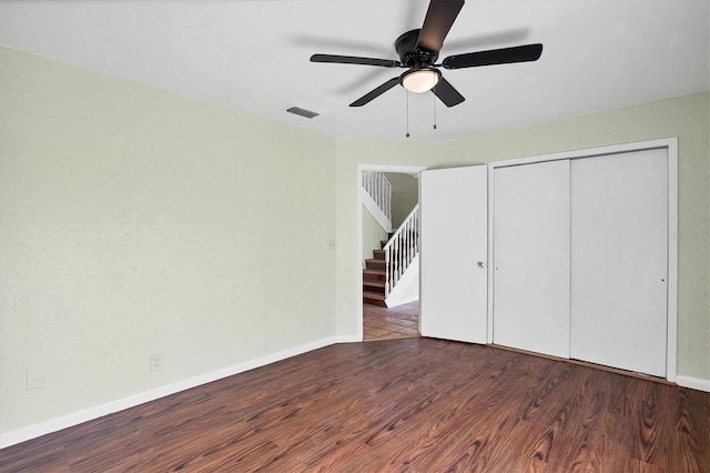 unfurnished bedroom with ceiling fan, a closet, and dark hardwood / wood-style floors