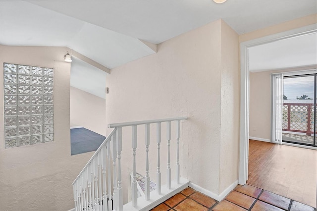 corridor featuring tile patterned flooring and lofted ceiling