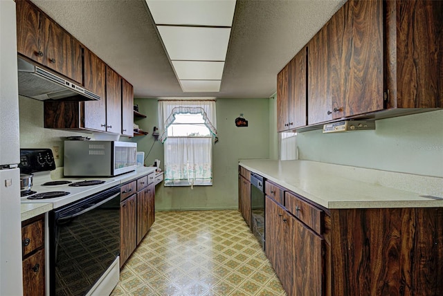 914 E 2nd St, Englewood, FL 34223 - kitchen featuring electric range oven, stainless steel microwave, under cabinet range hood, light flooring, and light countertops