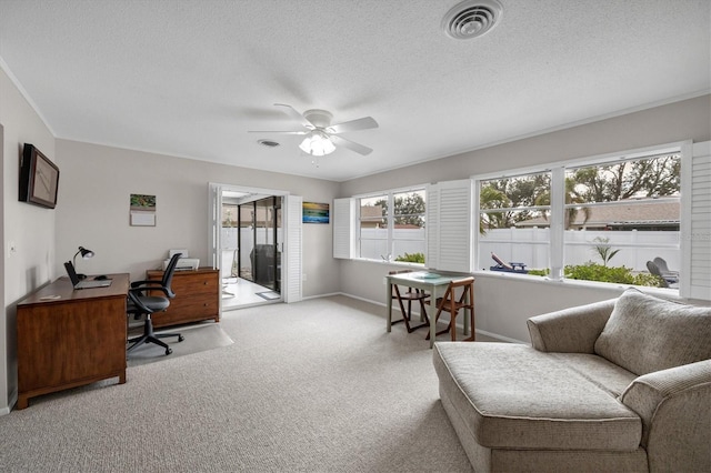 carpeted home office featuring a textured ceiling and ceiling fan