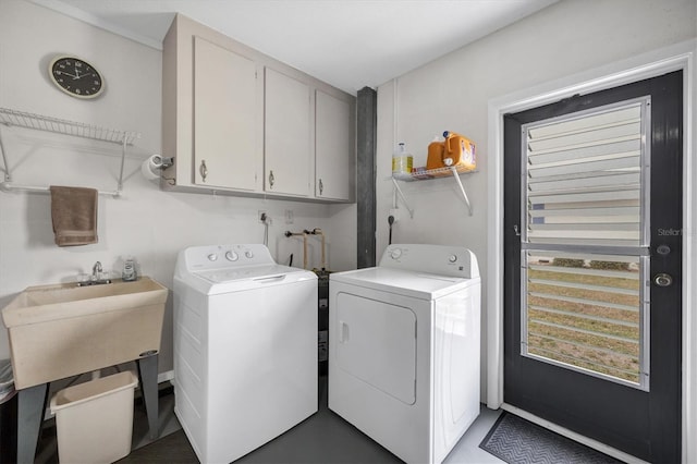 clothes washing area with cabinets and washing machine and clothes dryer