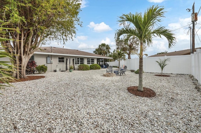 back of property with a fire pit and a patio