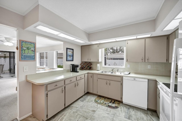 kitchen featuring white appliances, a sink, light countertops, crown molding, and backsplash