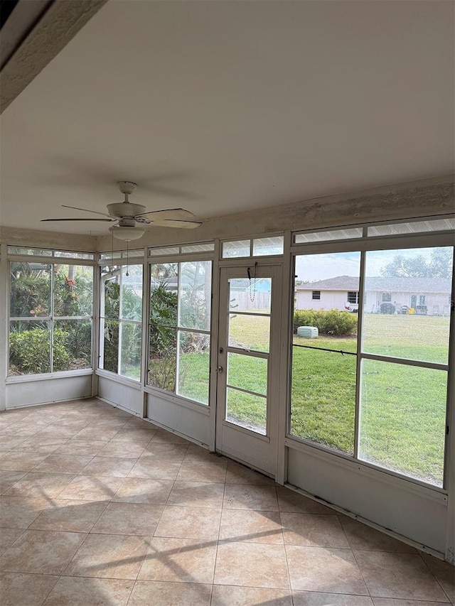 unfurnished sunroom with ceiling fan