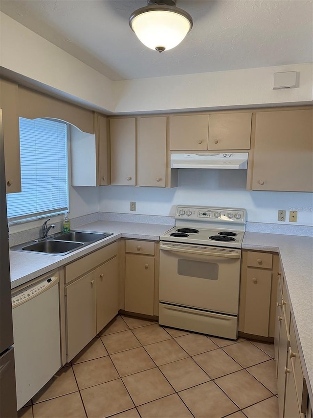 kitchen featuring sink, white appliances, cream cabinetry, and light tile patterned flooring