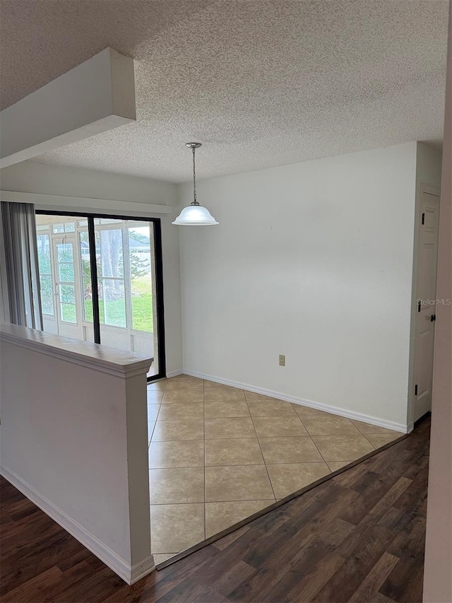 spare room with a textured ceiling and hardwood / wood-style flooring