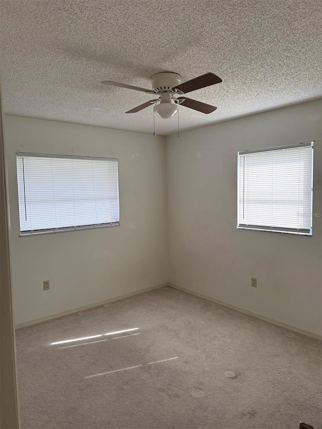 unfurnished room with ceiling fan, carpet, and a textured ceiling