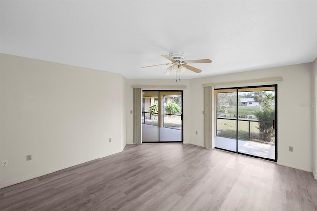 spare room with a wealth of natural light, ceiling fan, and light wood-type flooring