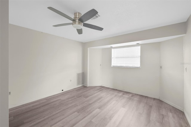 empty room with ceiling fan and light hardwood / wood-style flooring