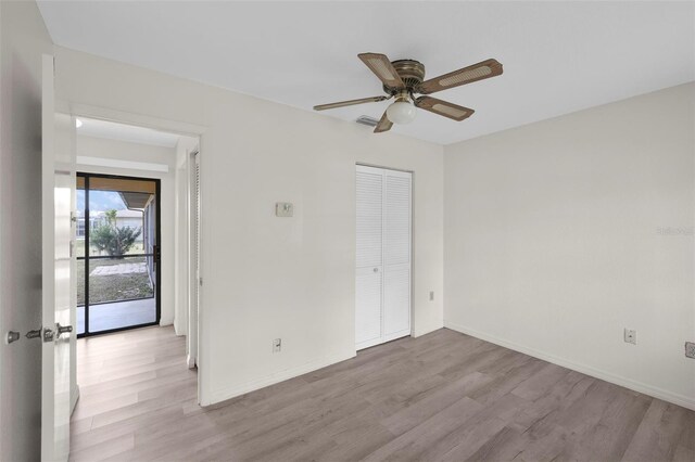 unfurnished bedroom featuring light hardwood / wood-style floors, a closet, and ceiling fan