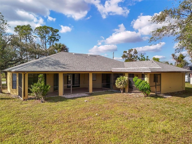 rear view of property featuring a sunroom and a lawn