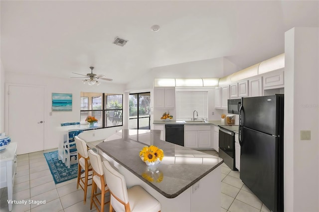 kitchen with white cabinetry, a center island, black appliances, sink, and a kitchen breakfast bar