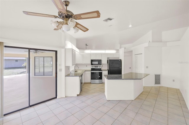 kitchen with vaulted ceiling, sink, light tile patterned floors, white cabinetry, and black appliances