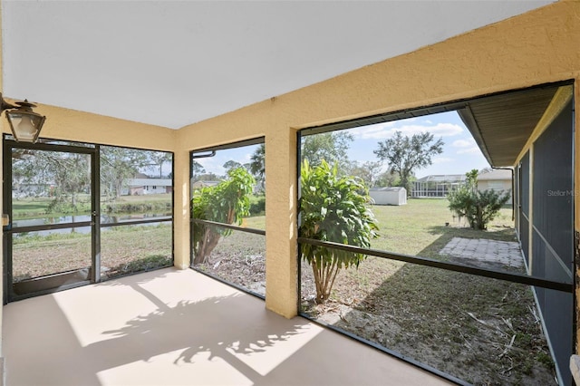 unfurnished sunroom featuring a water view