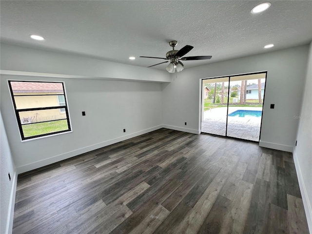 unfurnished room featuring dark wood-type flooring, ceiling fan, and a textured ceiling