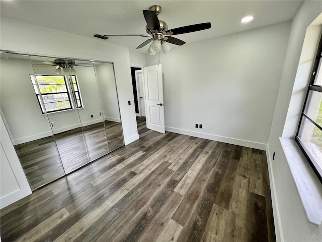 unfurnished bedroom with ceiling fan, dark hardwood / wood-style flooring, and a closet