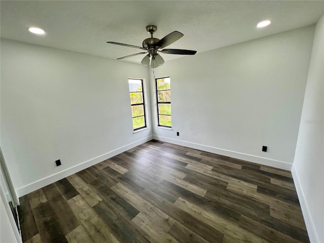 spare room featuring dark wood-type flooring and ceiling fan