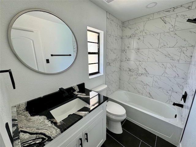 full bathroom featuring vanity, tiled shower / bath combo, tile patterned floors, and toilet