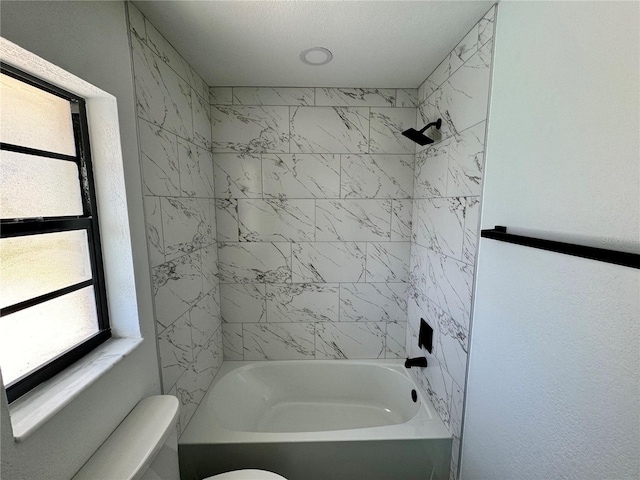 bathroom with tiled shower / bath and toilet