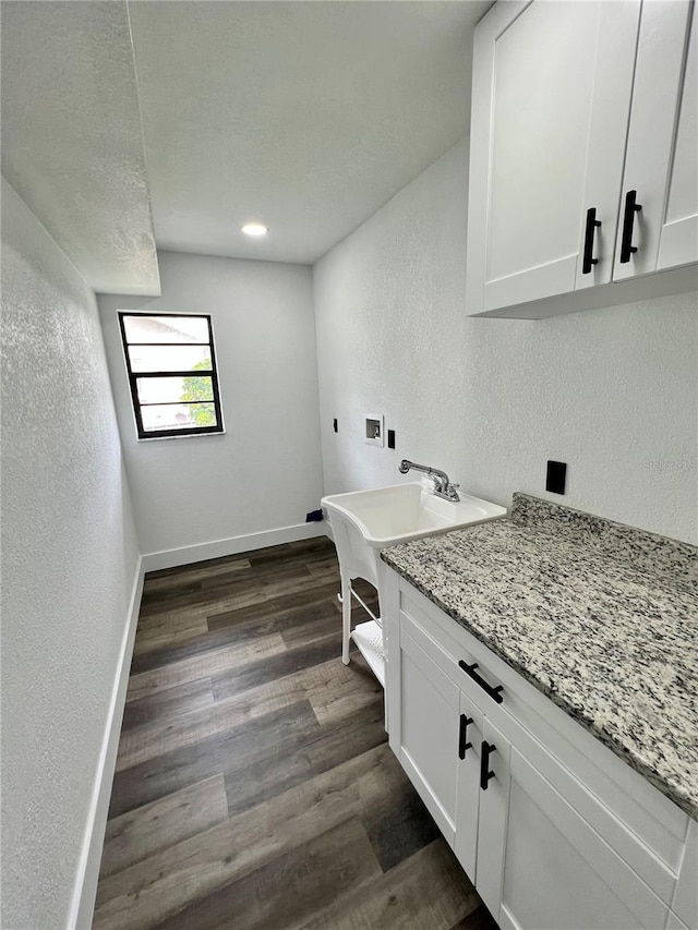 washroom featuring cabinets, a textured ceiling, dark hardwood / wood-style flooring, washer hookup, and hookup for an electric dryer