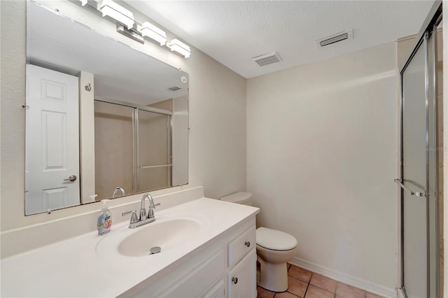 bathroom featuring toilet, a shower with door, tile patterned flooring, a textured ceiling, and vanity