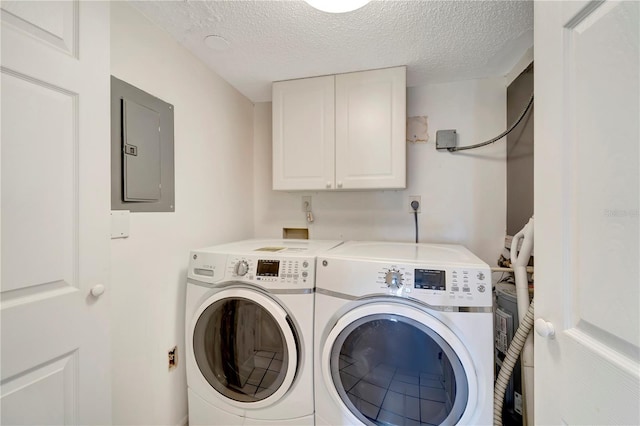 laundry room with cabinets, washer and clothes dryer, a textured ceiling, and electric panel