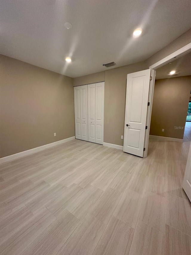 unfurnished bedroom with a closet and light hardwood / wood-style flooring