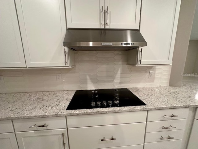 kitchen with decorative backsplash, white cabinets, and black electric stovetop