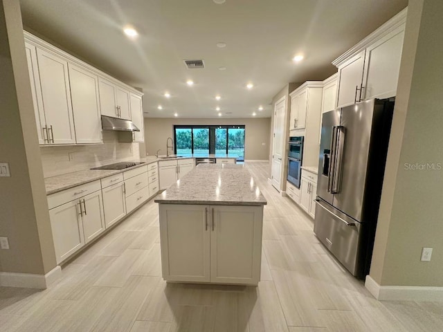 kitchen with appliances with stainless steel finishes, white cabinetry, sink, kitchen peninsula, and light stone counters