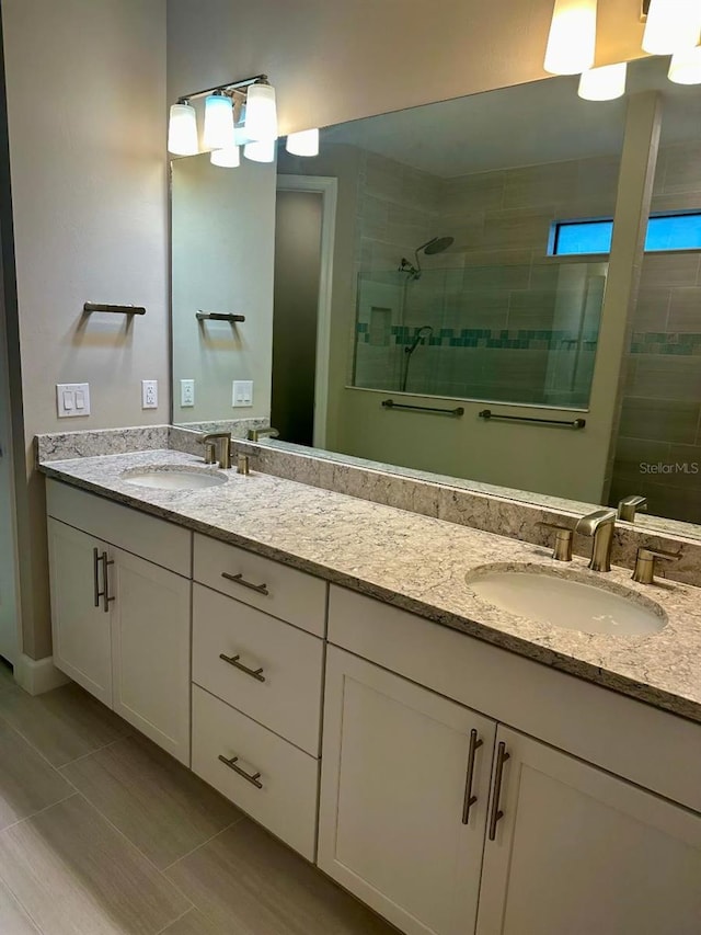 bathroom with tile patterned flooring, a shower with shower door, and vanity