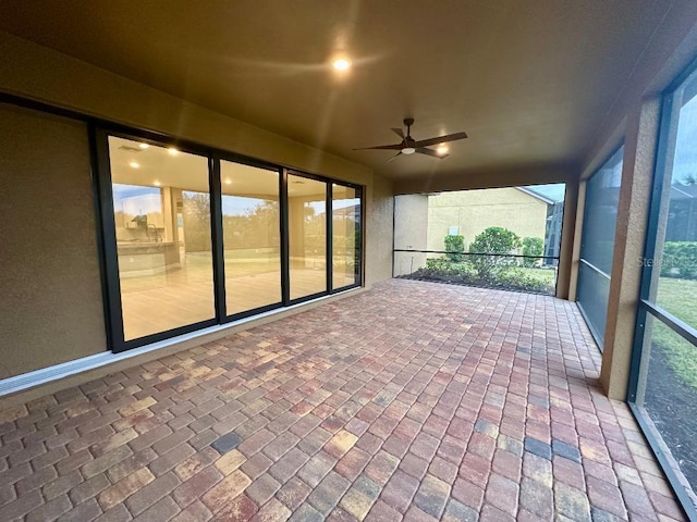 unfurnished sunroom with ceiling fan