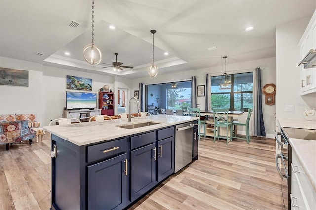 kitchen with stainless steel appliances, white cabinets, a raised ceiling, and sink