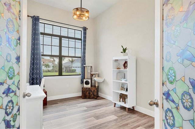 sitting room with light wood-type flooring and an inviting chandelier