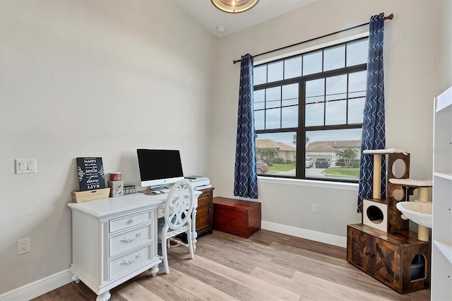 office with lofted ceiling and light wood-type flooring