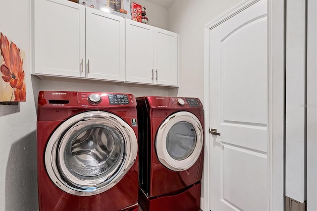 washroom featuring cabinets and washer and clothes dryer