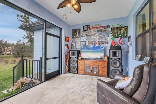 living room featuring ceiling fan and concrete flooring