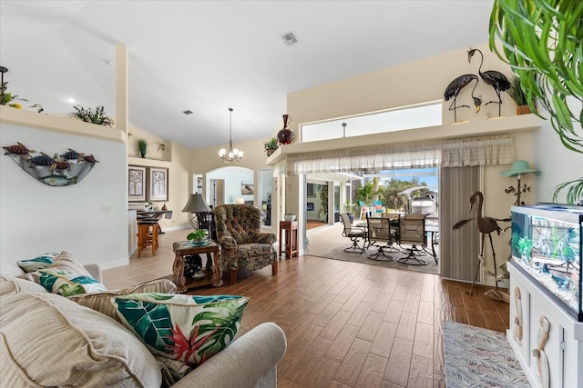 living room with high vaulted ceiling and a notable chandelier