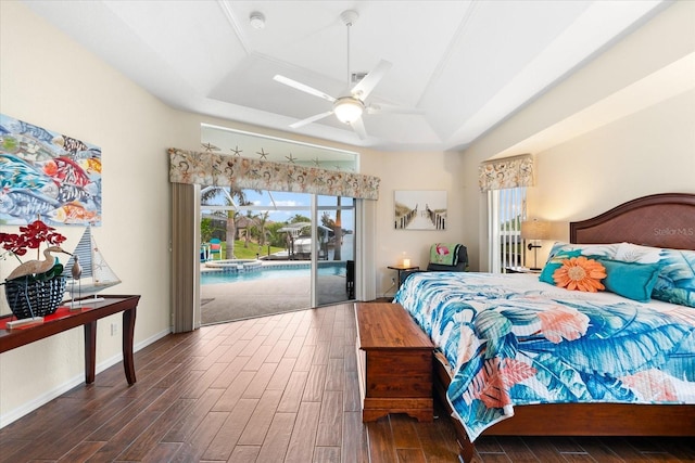 bedroom with ceiling fan, access to outside, multiple windows, and a tray ceiling