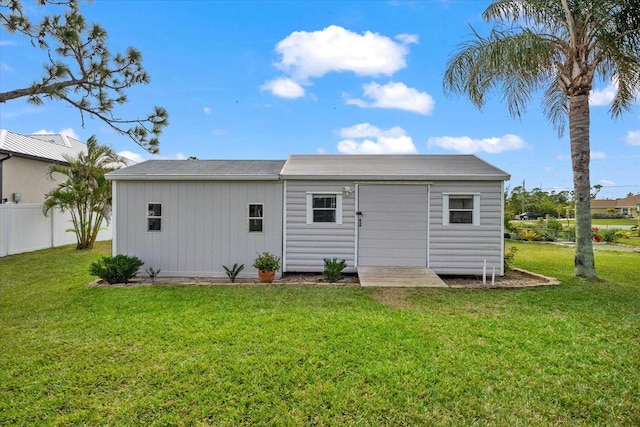 back of property featuring an outbuilding and a lawn