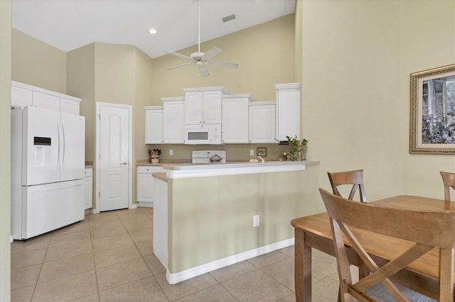 kitchen with high vaulted ceiling, light tile patterned floors, white cabinets, and white appliances