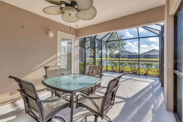 sunroom / solarium featuring a water view and ceiling fan