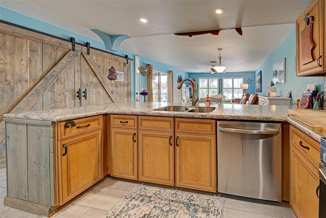 kitchen featuring dishwasher, sink, light tile patterned floors, ceiling fan, and kitchen peninsula