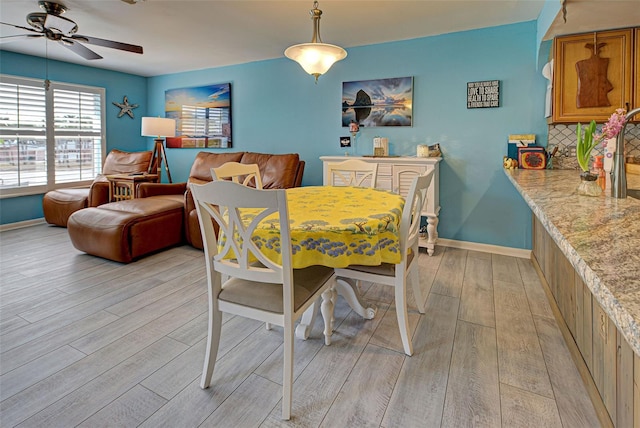 dining area with light hardwood / wood-style floors and ceiling fan