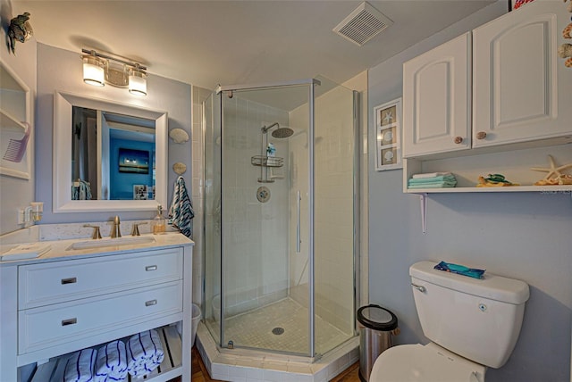 bathroom featuring vanity, toilet, and walk in shower